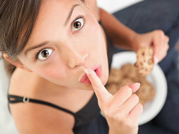 Woman eating cookies in secret