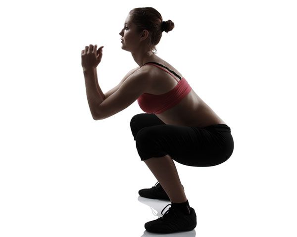 Woman performs a bodyweight squat