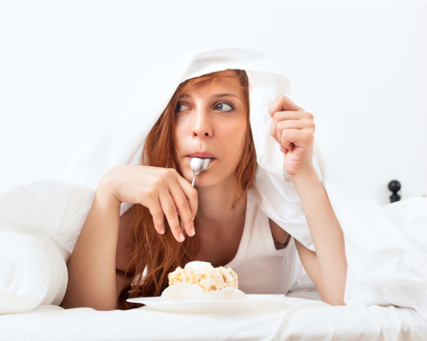 Woman eating under blanket